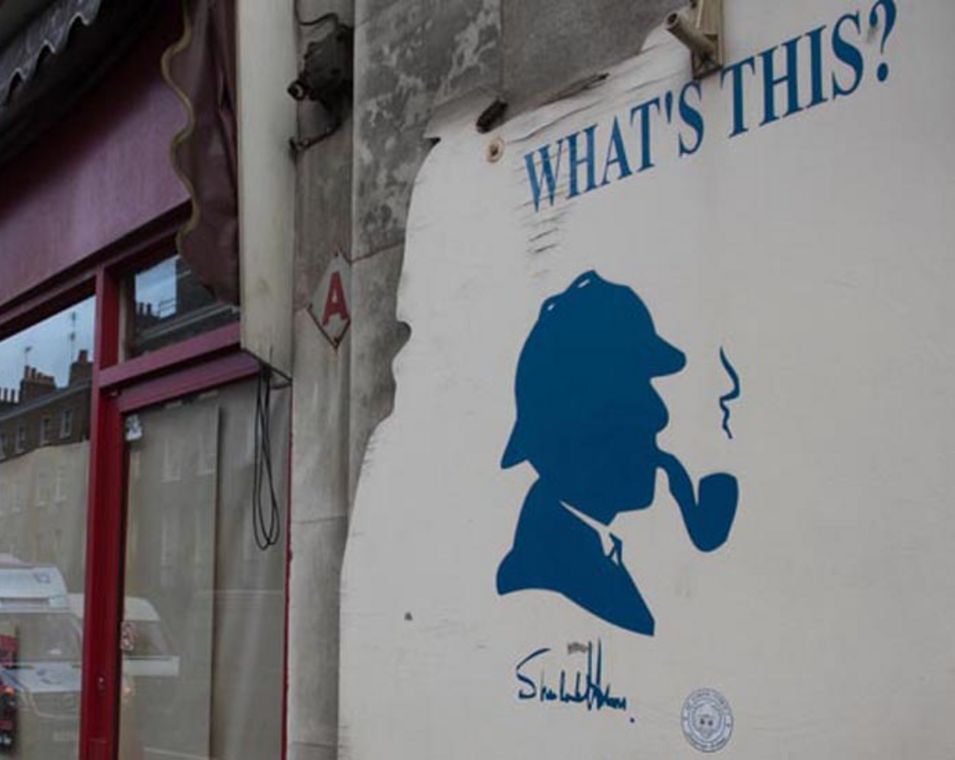 Plakat mit Kopf von Sherlock Holms vor Restaurant mit Schriftzug "What's this?"