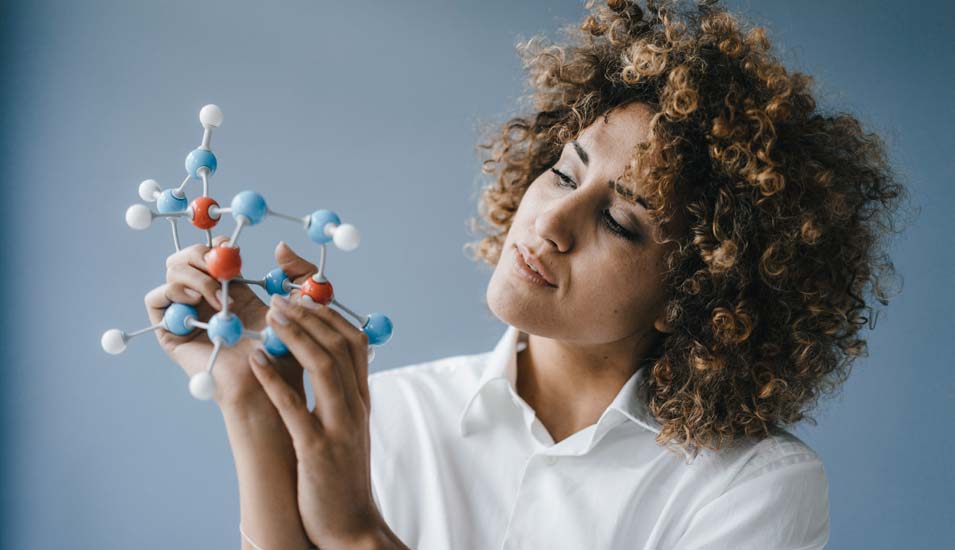 Eine Forscherin betrachtet ein Modell einer Molekülstruktur