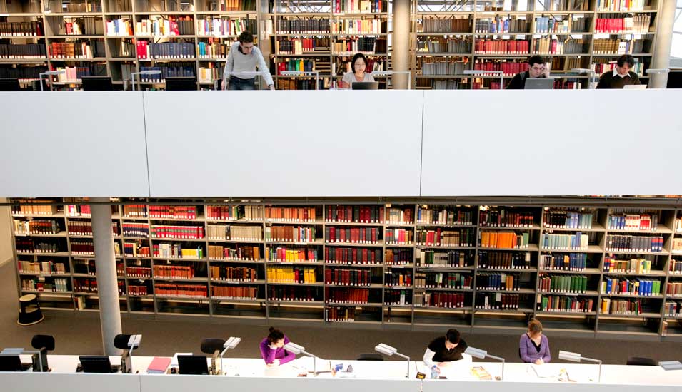 Studierende sitzen in einer Bibliothek und lernen.
