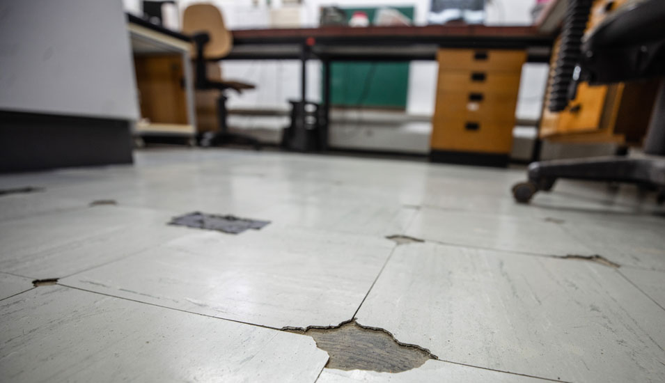 Detailaufnahme des Bodens eines Labors: Teile der Bodenplatten sind abgebrochen.