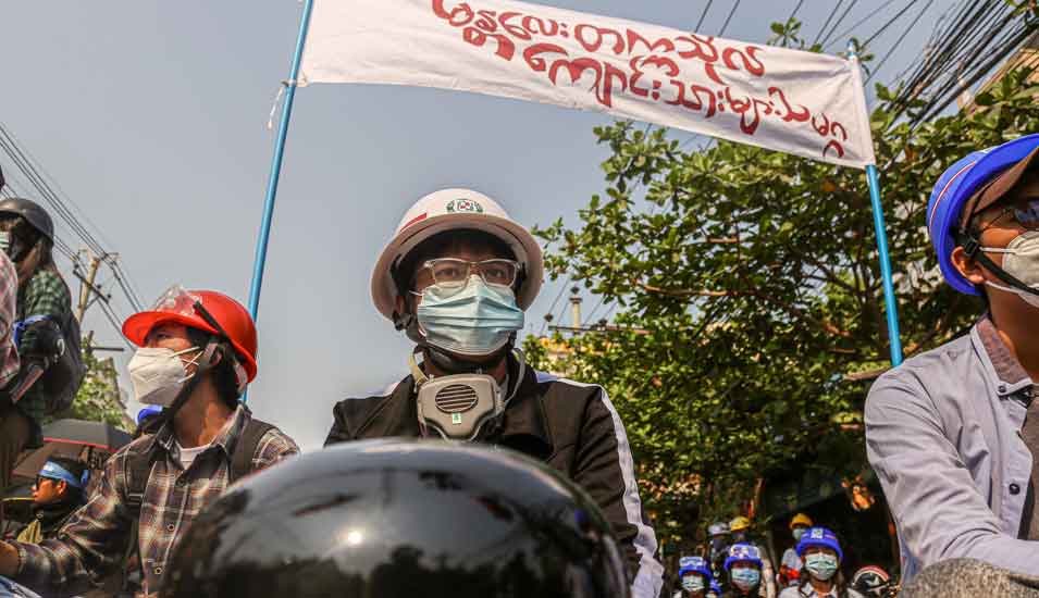 Ein Student sitzt Anfang März 2021 unter dem Banner der Studierendenunion der Mandalay Universität Myanmar während einer Demonstration gegen den Militärputsch, Anfang Februar 2021.
