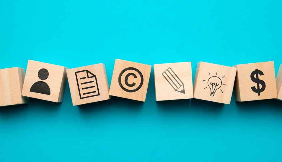 Verschiedene Icons für das Urheber- und Patentrecht sowie Erfindungen auf Holzklötzen