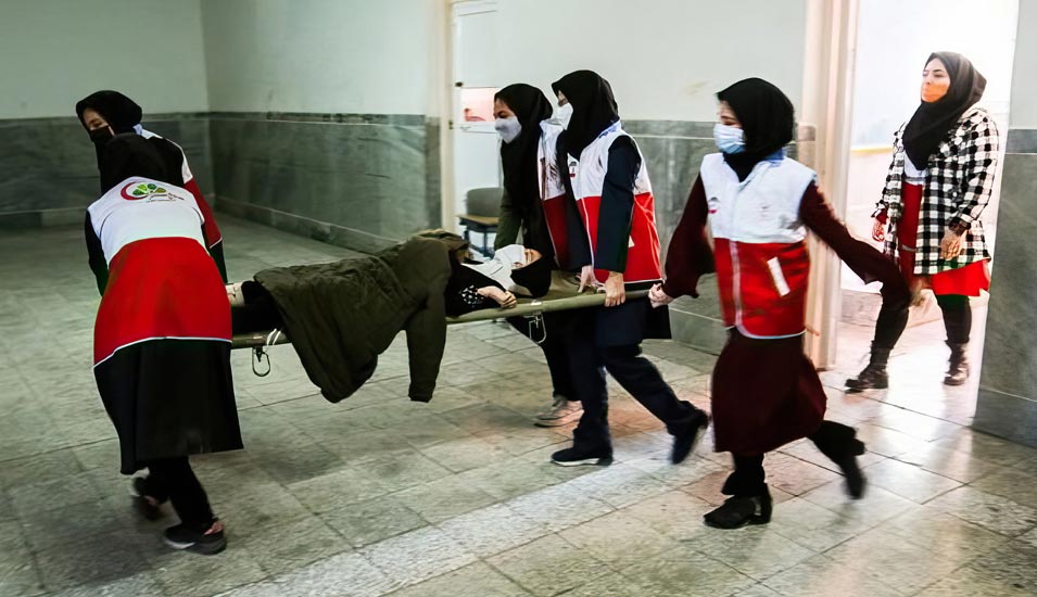 Gasangriffe auf Schülerinnen im Iran: Helferinnen tragen ein vergiftetes Mädchen in einer Grundschule in Teheran auf einer Bahre.